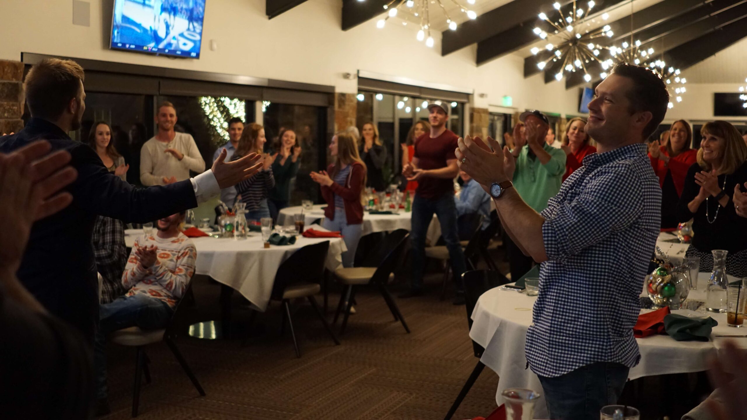 A private dinner audience giving a standing ovation